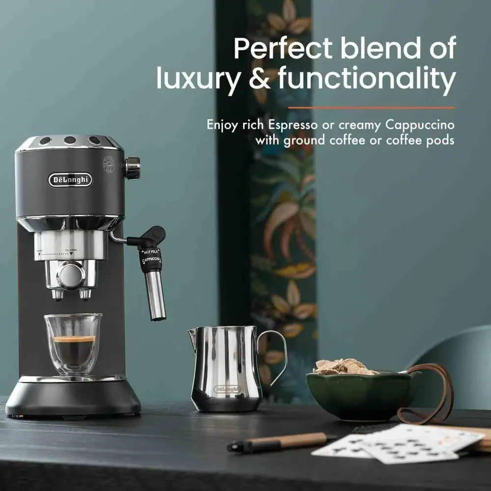 اسپرسوساز دلونگی EC685 روی میز با فنجان قهوه و پارچ استیل فومگیر شیر