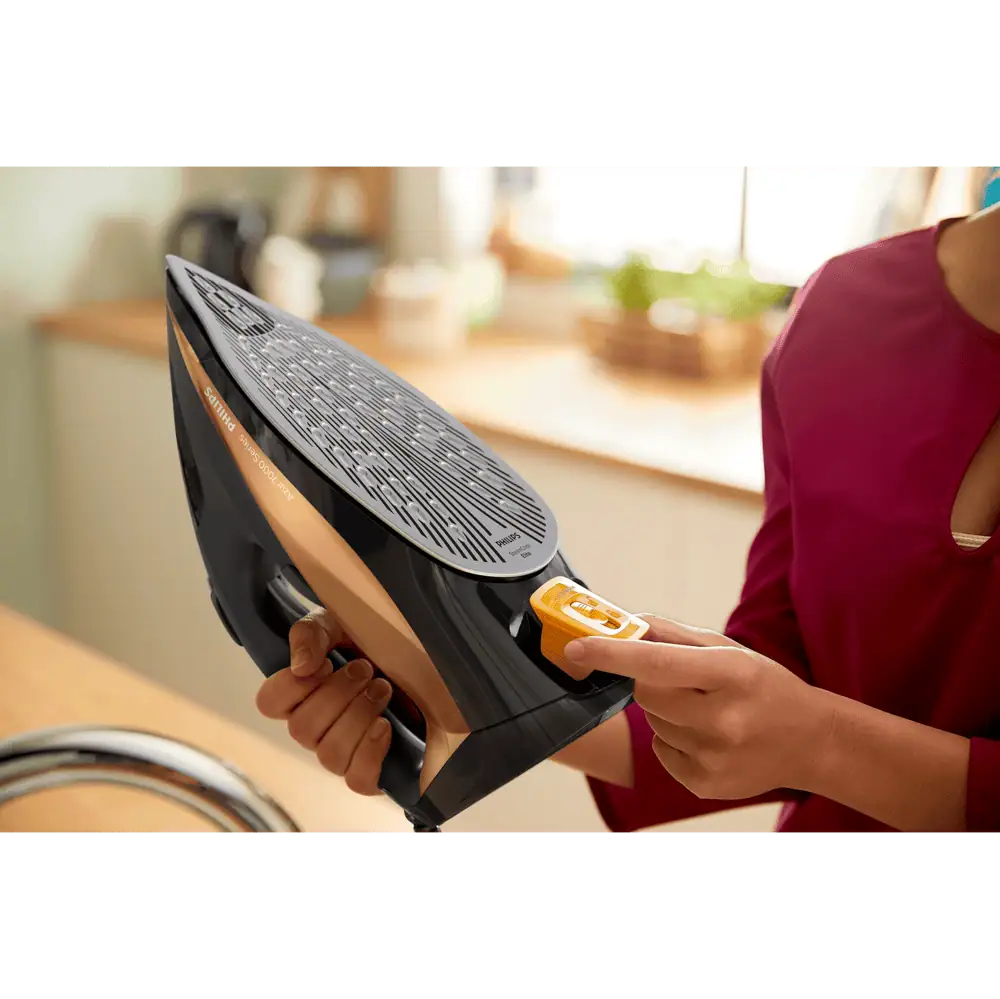 نمای نزدیک از بخش تمیزکننده رسوبات (Calc Clean) اتو فیلیپس DST7040 در حال تخلیه